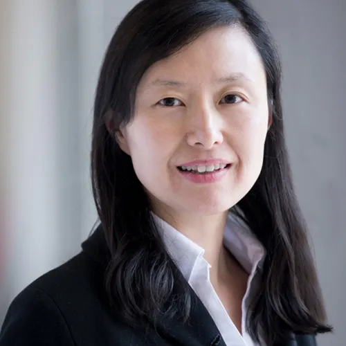 A woman in a business suit smiling for the camera.